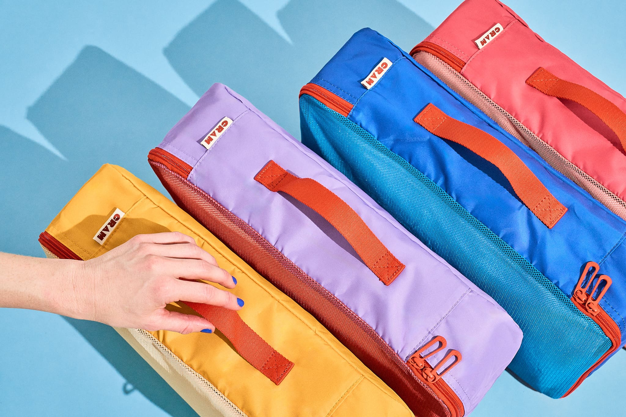 Colorful Cram travel packing cubes on a blue background