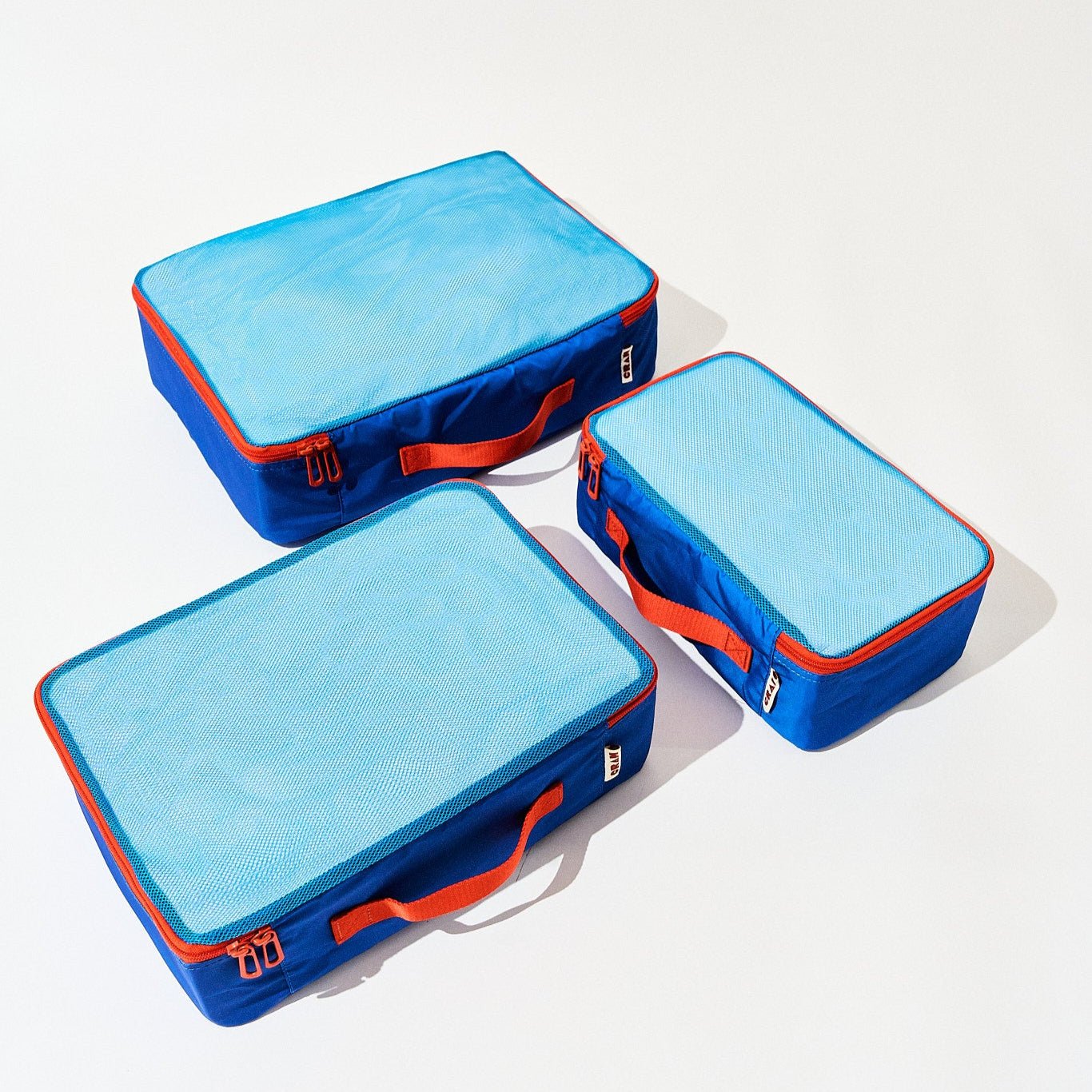 3 sizes of pacific blue Cram packing cubes suitcase organizers flat view