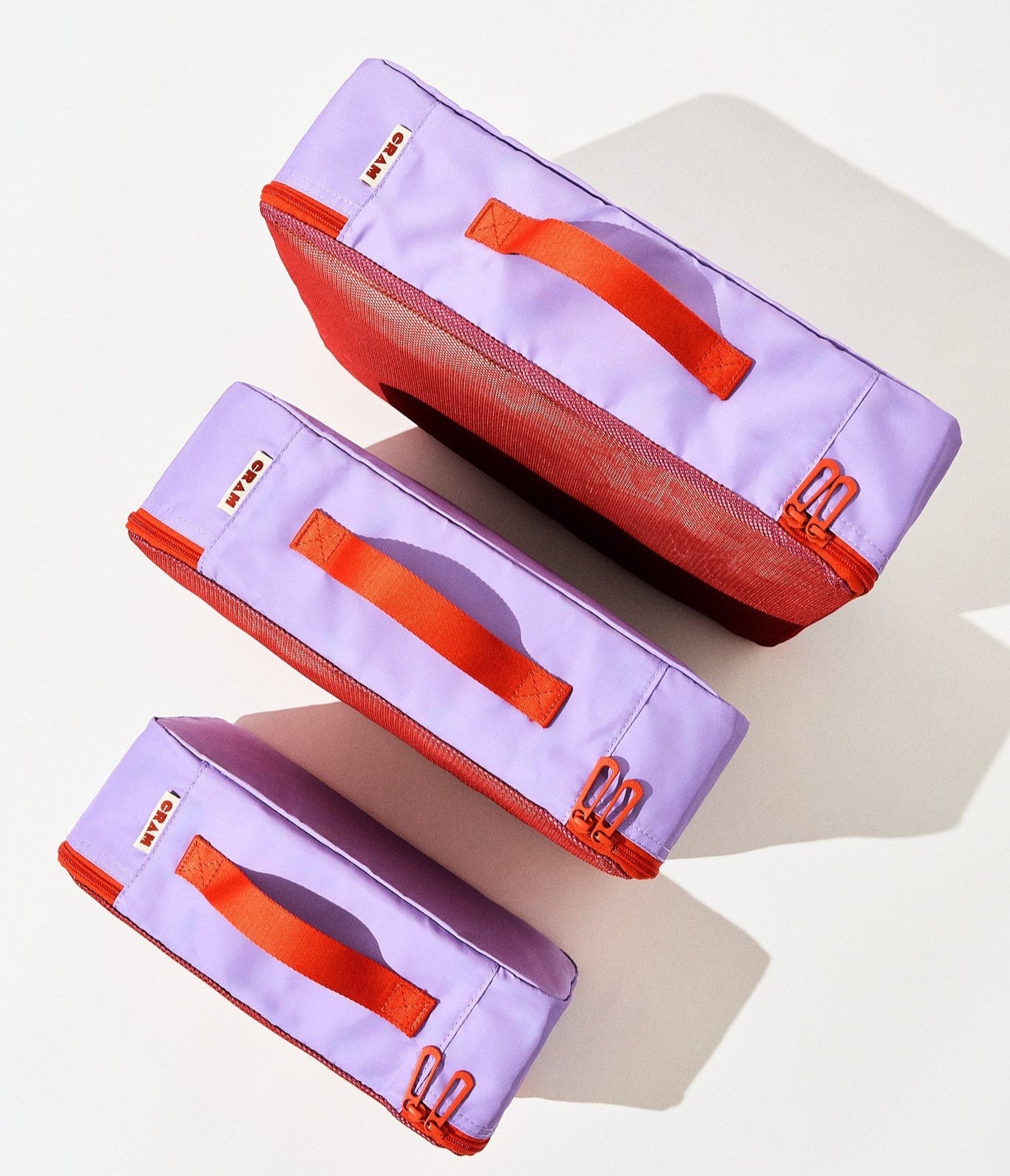 3 sizes of twilight purple Cram packing cubes suitcase organizer standing upright in front of each other, top down view
