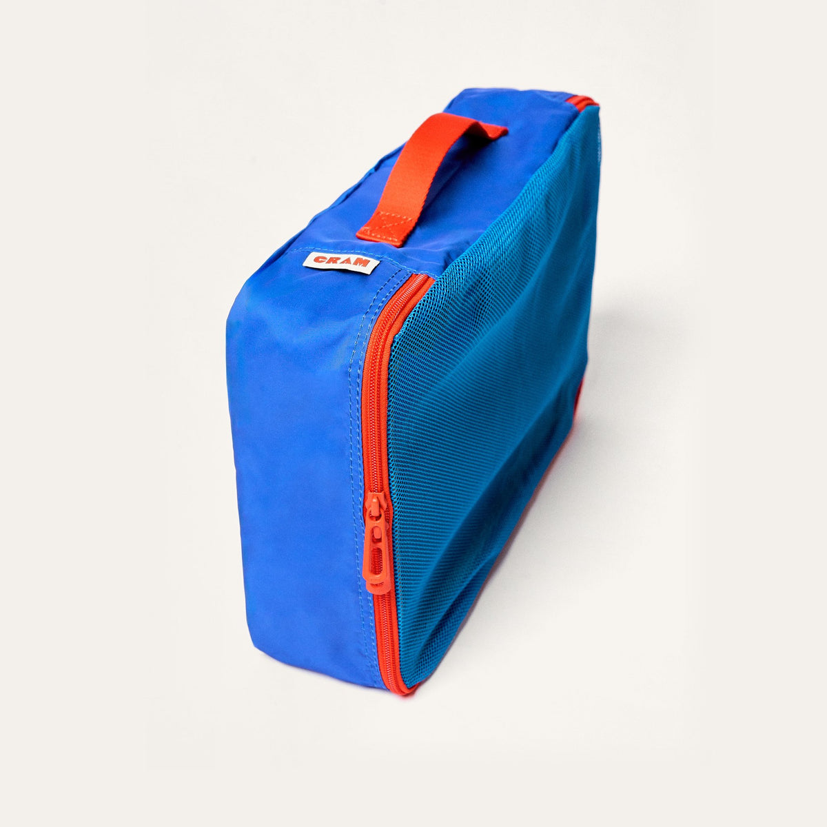 Pacific blue Cram Medium packing cube standing upright, with a mesh side and red zipper