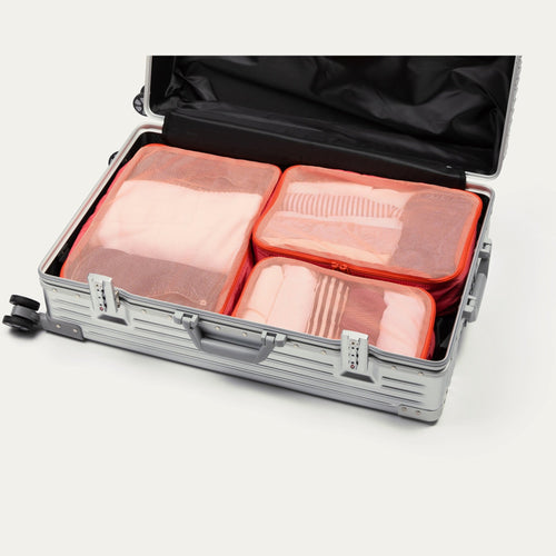 Bloom pink Cram packing cubes packed in an open suitcase