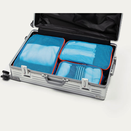 Pacific blue Cram packing cubes packed in an open suitcase