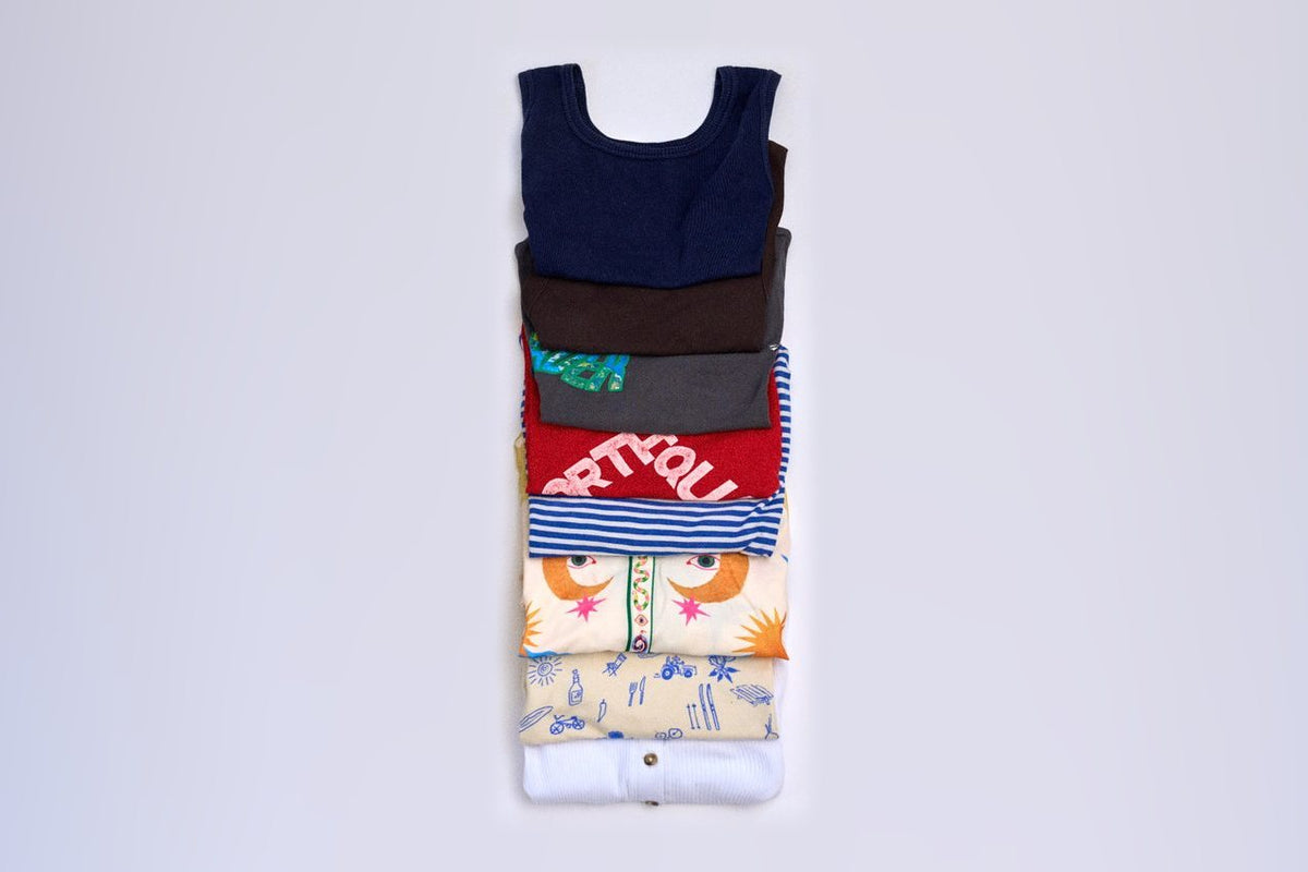 Flat lay of 8 shirts and tops that fit in 1 Cram Medium packing cube